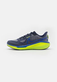 Scarpa da corsa blu navy e grigia con suola gialla brillante, logo Nike blu e marchio "ZoomX" sul lato.