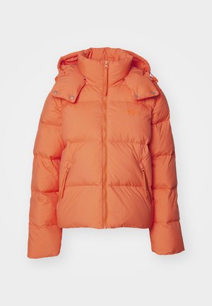 Giacca a vento arancione con colletto alto, chiusura con zip e tasche laterali. Realizzata in tessuto trapuntato, con un accento del logo sul petto.