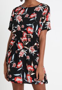 Schwarzes Kurzarmkleid mit floralen Mustern in Rot und Hellblau, mit einem elastischen Bund für einen figurbetonten Stil und eine lockere Passform.