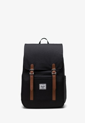 Čierny batoh z odolnej tkaniny s hnedými koženými remienkami, preklopom na zatváranie a predným vreckom s logom značky.