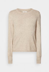 Pull beige en maille avec un col rond, des manches longues et des poignets côtelés. Texture douce avec une coupe légèrement ample.