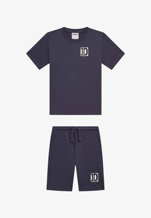 Completo composto da T-shirt a maniche corte blu navy e pantaloncini con piccole patch rettangolari del logo sul petto e sulla coscia sinistra, vita elastica con coulisse.