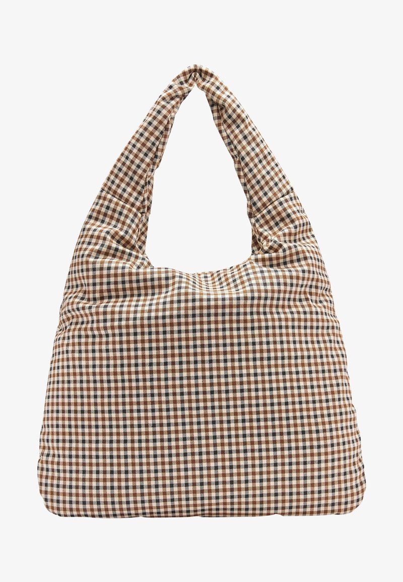 Sac à épaule en tissu doux avec un motif à carreaux marron, noir et blanc, et une large sangle formant une poignée en boucle.