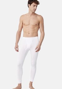 Leggings blancos ajustados hechos de un material elástico. Presenta una cinturilla reforzada y una abertura horizontal en la bragueta. Textura suave.