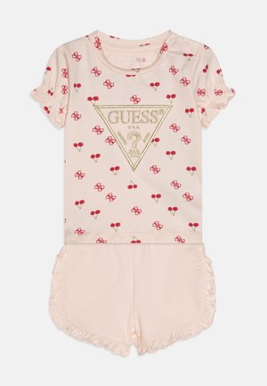Lichtroze pyjama set met korte mouwen, voorzien van een rode kersenprint, een gouden driehoeklogo op de top en kantaccenten op de shorts.