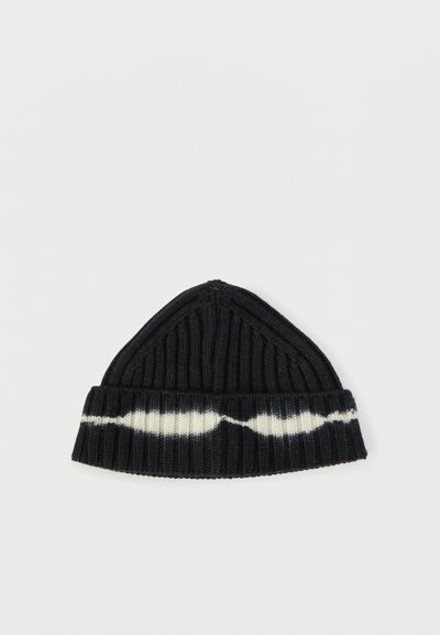 Bonnet noir en tricot côtelé avec un bord plié orné d'un motif de bandes blanches ondulées tout autour.