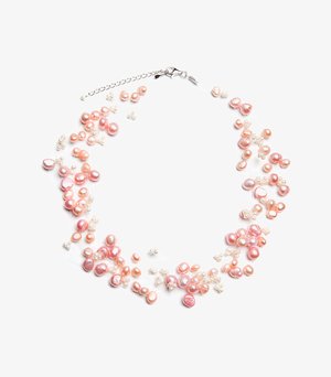 Rožinės ir kreminės perlų spalvos įvairių formų yra surikiuoti ant skaidrios virvutės. Pridedamas sidabrinis segtukas ir grandinėlės ilgintojas, kad būtų galima reguliuoti ilgį.