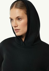 Czarny hoodie o gładkiej fakturze, z głębokim dekoltem w formie kaptura i dopasowanym kroju. Brak widocznych wzorów i detali metalowych.