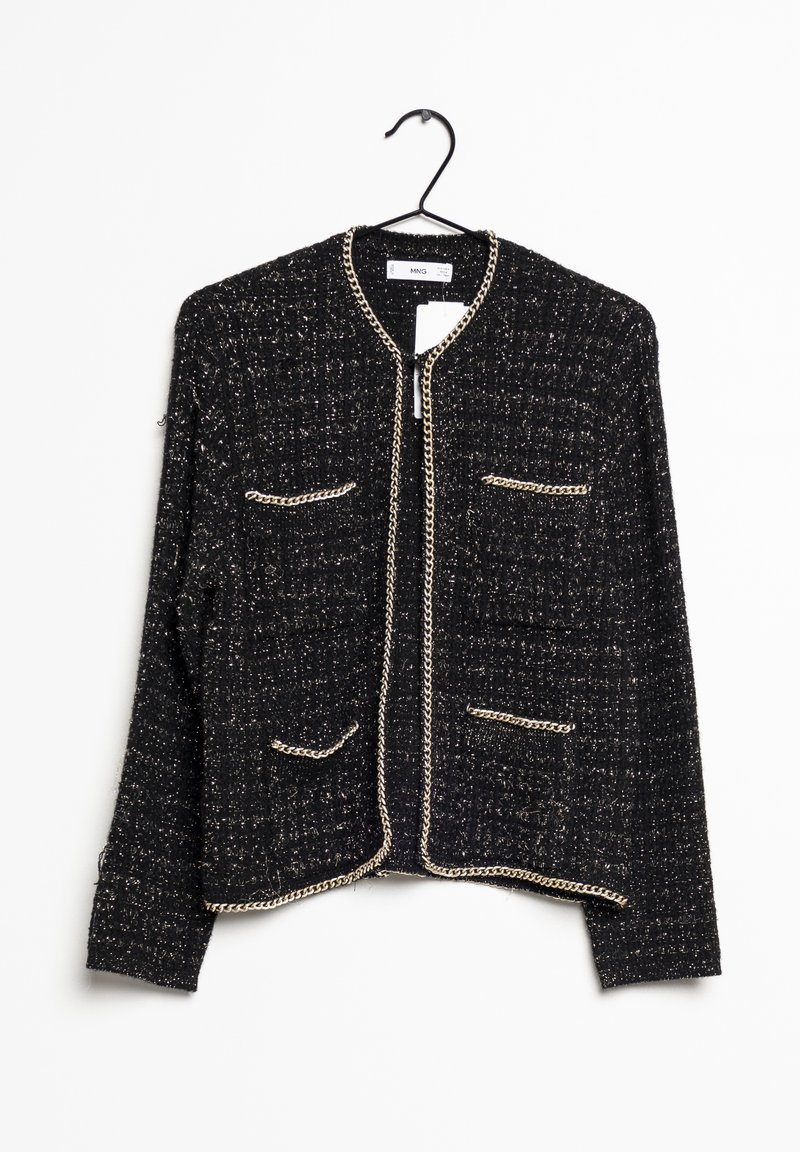 Veste noire texturée avec bordure en chaîne dorée, quatre poches avant et sans col, suspendue sur un cintre noir sur fond blanc.
