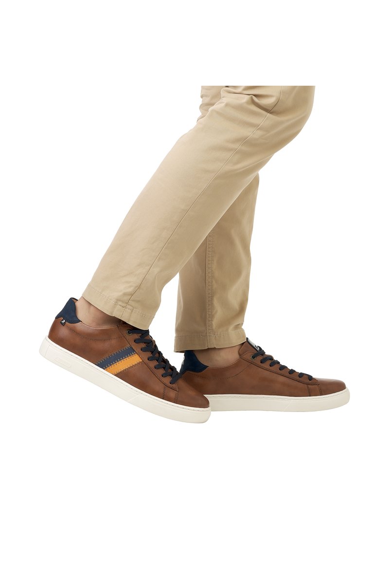 Brown leather sneakers with navy accents, white rubber sole, and orange stripe detail. Laced design and smooth texture.