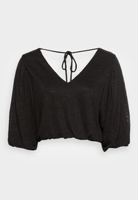 Blusa cropped preta com um decote em V profundo, mangas bufantes e fecho de laço nas costas. Feita de um tecido leve e texturizado.