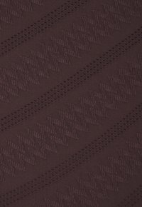 Burgunderfarbener Textilstoff mit Zickzackmuster und kleinen Perforationen, die einen geschichteten visuellen Effekt über die Oberfläche erzeugen.