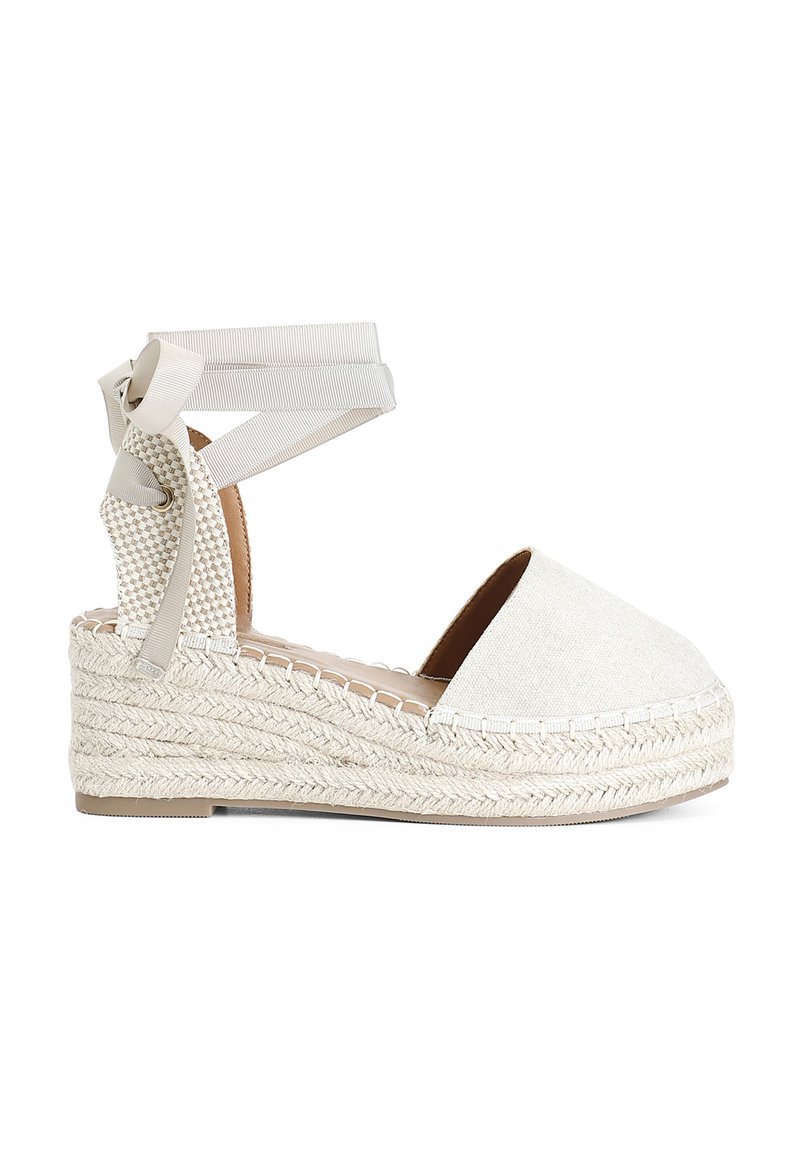Beige espadrilové sandály na klínu s textilním svrškem, pletenou juty podešví a stužkami na kotníky. Kulatá špička a polstrovaná stélka.