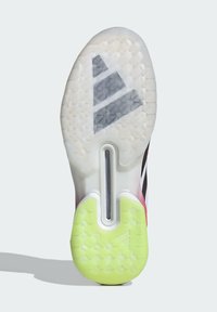 Semelle d'une chaussure de sport avec une adhérence translucide blanche et jaune néon, un motif de semelle en forme d'hexagone et un design de bande centrale noire.