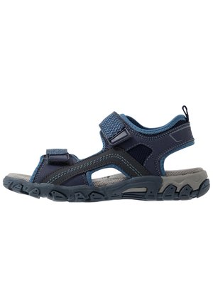 Marineblaue und graue Outdoorsandale mit verstellbaren Klettverschlüssen, gepolstertem Fußbett und robuster Gummisohle, entwickelt für Komfort und Haltbarkeit.