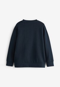 Tengerés kék pulóver kerek nyakkal, hosszú ujjal és bordázott mandzsettával és szegéllyel. Simább textúra, látható minták vagy díszítések nélkül.