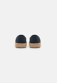 Espadrilles en tissu marine avec une semelle en jute tressé. Design à talon fermé et à bout rond. Texture lisse et construction légère.