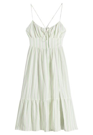 White midi dress with thin green vertical stripes, adjustable spaghetti straps, front tie at bust, gathered waist, and side slit.