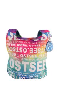 Multikleurige stoffen tas met een gradient ontwerp met vetgedrukte witte tekst die "OSTSEE" herhaalt. Korte handgrepen en een ronde label eraan bevestigd.