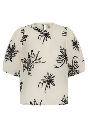 Blouse crème à manches courtes bouffantes, encolure ronde, avec motifs floraux abstraits brodés en noir.