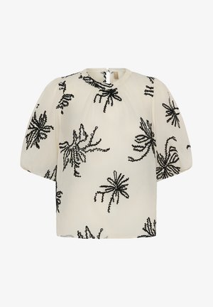 Blouse crème à manches courtes bouffantes, encolure ronde, avec motifs floraux abstraits brodés en noir.