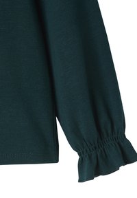 Dunkelgrünes Langarmshirt mit gerafftem Saum und Rüschendetails aus weichem, strukturiertem Stoff, auf einem weißen Hintergrund präsentiert.