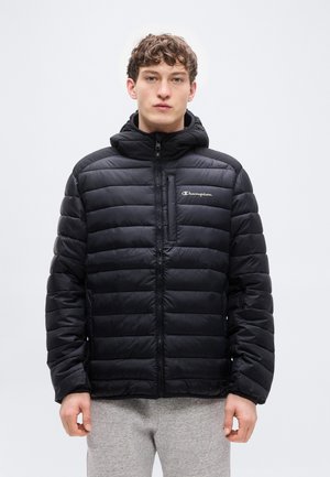 Črna napolnjena jakna z zadrgo spredaj in kapuco. Ponaša se s horizontalnim prešitim vzorcem in majhnim izvezenim logotipom na prsih.