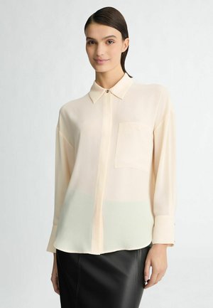 Leichte, transparente Bluse in sanftem Pfirsich mit einem geknöpften Kragen, langen Ärmeln, einer Brusttasche und einem dezenten Farbverlauf zu hellgrün am Saum.