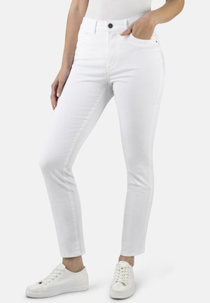 Schlanke weiße Jeans aus einem Baumwollgemisch, mit einem klassischen Fünf-Taschen-Design und einem Reißverschluss- und Knopfverschluss. Kombiniert mit weißen Sneakern.
