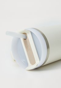 White tumbler with a stainless steel rim, clear straw, and a beige accent for grip. Smooth finish with a matte exterior texture.