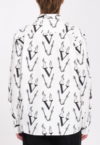 Weißes Langarmhemd mit einem schwarzen Stacheldraht- und stilisierten "V"-Muster, klassischem Kragen und Knopfmanschetten.