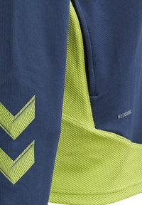 Marinblå sweatshirt med texturerade limegröna detaljer, som har diagonala randiga chevronmönster och "BECOOL"-logotypen.