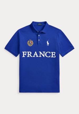 Μπλε πόλο με το κείμενο "FRANCE", έμβλημα της Γαλλίας με σημαία και δάφνινο στεφάνι, και λευκό λογότυπο Polo Ralph Lauren με άλογο στο στήθος.