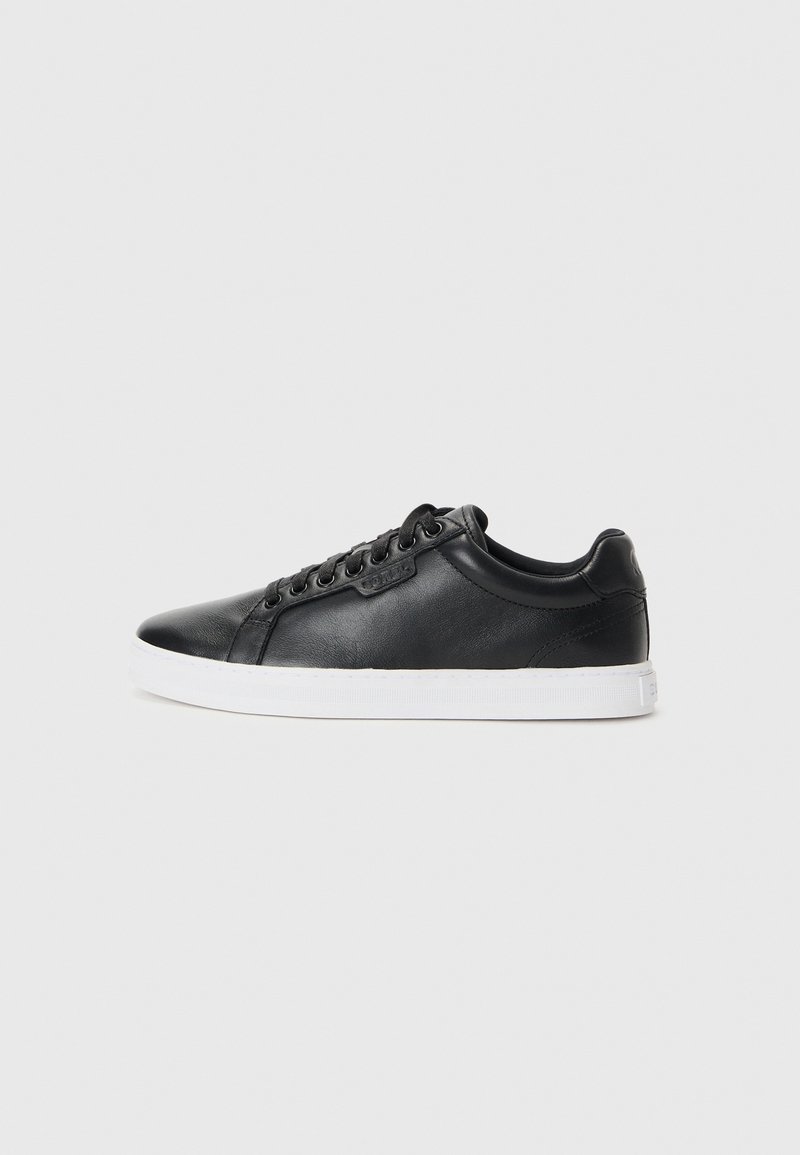 Czarne skórzane sneakersy o gładkiej powierzchni, okrągłym czubku, białej gumowej podeszwie i sześcioma oczkami do sznurowania. Dyskretne logo na boku.