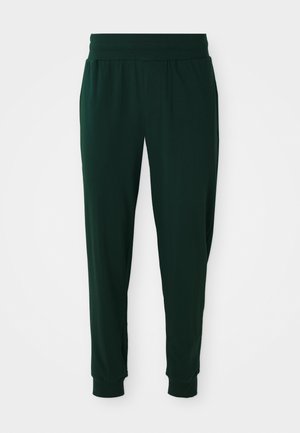 Mørkegrønne joggebukser med elastisk midje og tettsittende mansjetter. Laget av mykt stoff, med en løs passform og minimalisk design.