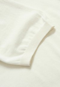 Valkoinen puuvillakangas, jossa on resorimainen hihansuu. Sileä rakenne, hieman joustava; tarjoaa puhtaan, minimalistisen muotoilun, joka sopii monenlaiseen käyttöön.