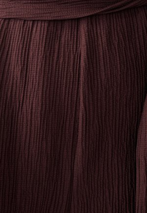 Tissu texturé bordeaux avec des plis verticaux et une taille froncée. Matériau doux avec une couleur riche et profonde.