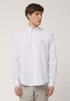 Camisa de dress blanca de manga larga con cuello abotonado, que presenta un sutil patrón de puntos y un pequeño logo azul en el pecho.