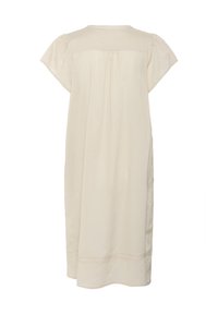 Robe beige clair à mi-mollet en tissu doux, avec des manches courtes bouffantes, un col rond et des détails en dentelle délicate au niveau de l'ourlet.