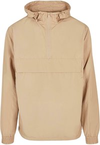Giacca pullover beige con cappuccio realizzata in materiale leggero, con chiusura mezza zip, polsini elasticizzati e tasca frontale.