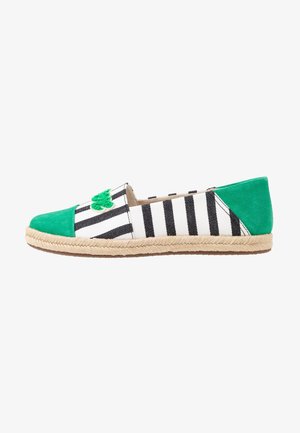 Espadrille en toile rayée noir et blanc avec des accents en daim vert, bout rond et semelle en corde. Présente un détail décoratif vert sur le devant.