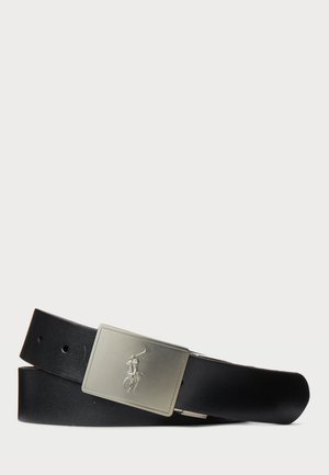 Cinturón de cuero negro con una hebilla rectangular de metal plateado que presenta un logotipo en relieve. El cinturón tiene múltiples agujeros para un ajuste variable.