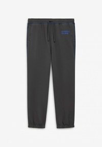 Pantaloni jogger grigi con vita elasticizzata e cordoncino. Presentano tasche laterali e dettagli blu con il logo "PALACE" ricamato in blu.