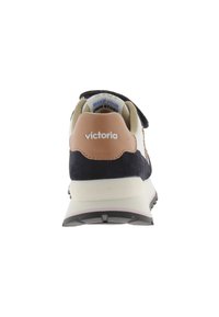 Sneaker in suede blu navy con accenti beige e suola bianca. Presenta una linguetta sul tallone con il logo "victoria" e una striscia in Velcro per la chiusura.