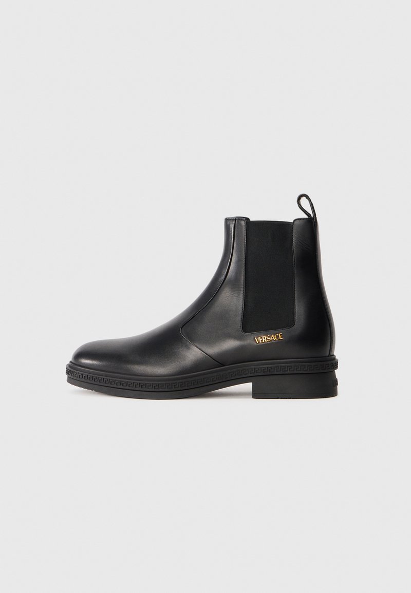 Botine negre din piele cu panou elastic pe lateral, toc mic, tab de prindere la spate și logo-ul auriu Versace aproape de talpă.
