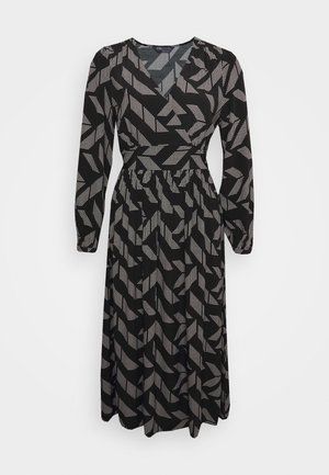 Vestido negro de manga larga con un patrón geométrico en blanco. Escote en V, cintura ajustada y falda fluida. Hecho de una tela ligera.