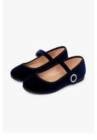 Zapatos Mary Jane de terciopelo azul marino con un acento de hebilla plateada redonda y plantillas acolchadas. Presentan una suela plana y una punta ligeramente redondeada.