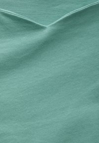 Vaaleansininen kangas, jossa on ribbitekstuuri ja lievä kiilto, aseteltu näyttämään V-mallinen kaula-aukko ja sileä pinta.