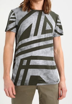 Szary i zielony t-shirt w paski z abstrakcyjnymi wzorami geometrycznymi. Okrągły dekolt, krótkie rękawy, wykonany z miękkiej mieszanki bawełny.