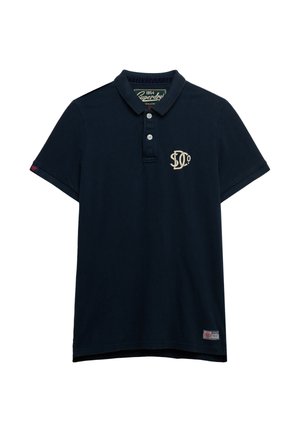Polo blu navy scuro in cotone. Presenta un colletto, tre bottoni e un logo color crema sul petto. Maniche corte e orlo dritto.